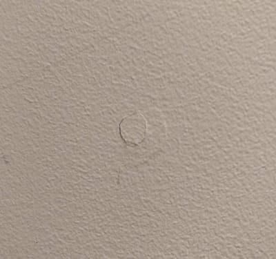 Picture of drywall cracking around a screw that has lost its holding power